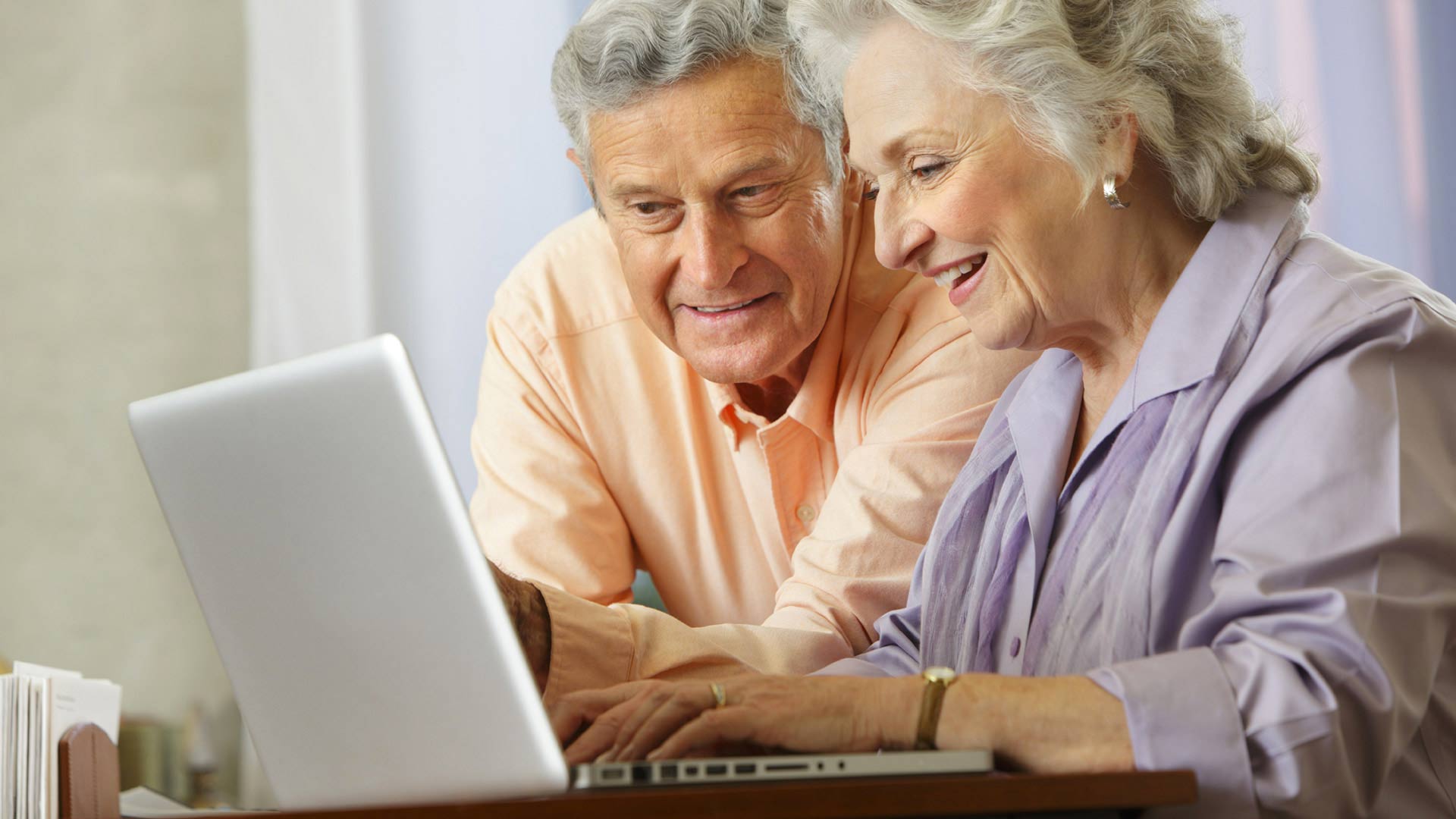Couple de seniors devant un ordinateur portable