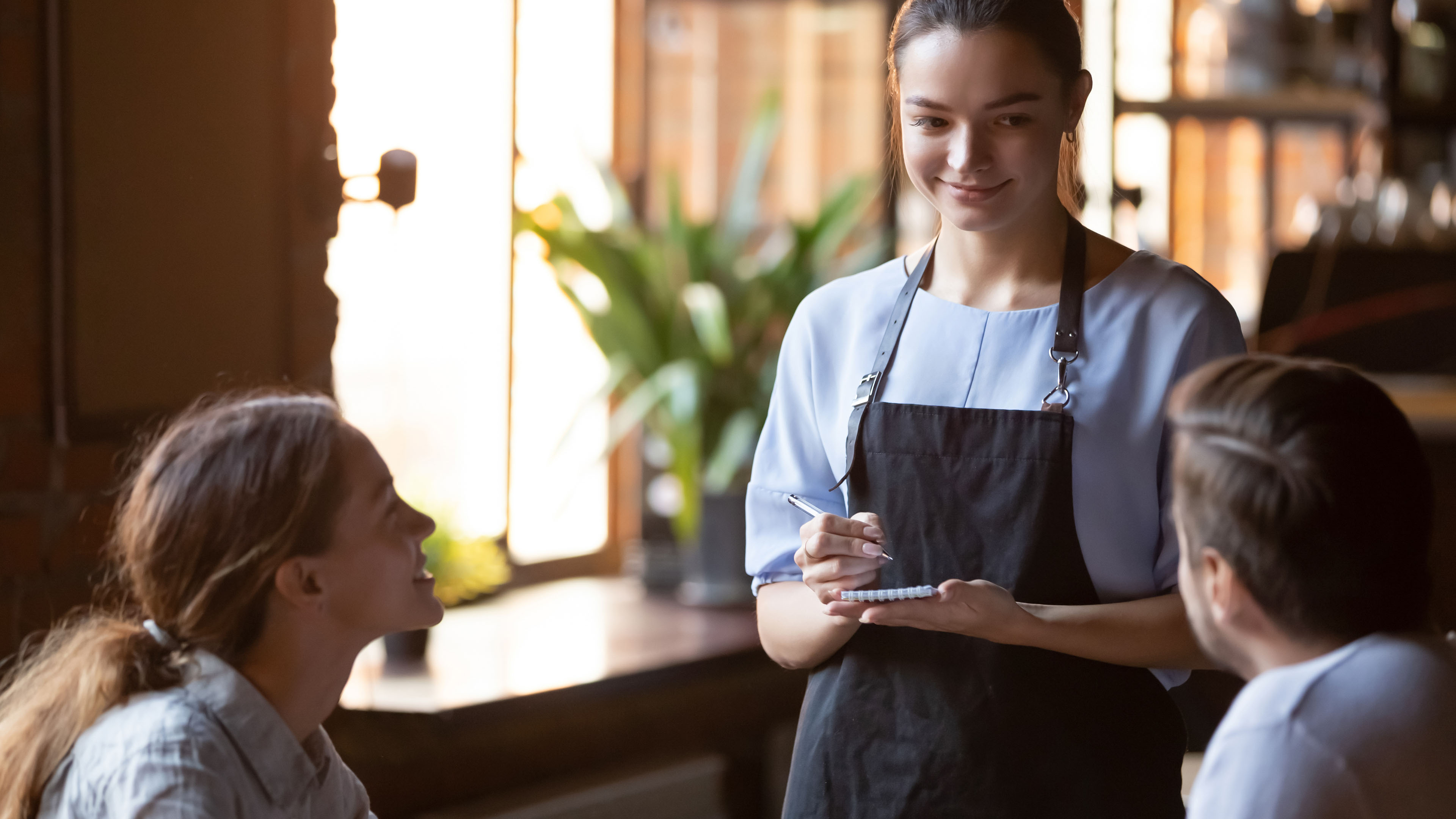 serveuse face à des clients