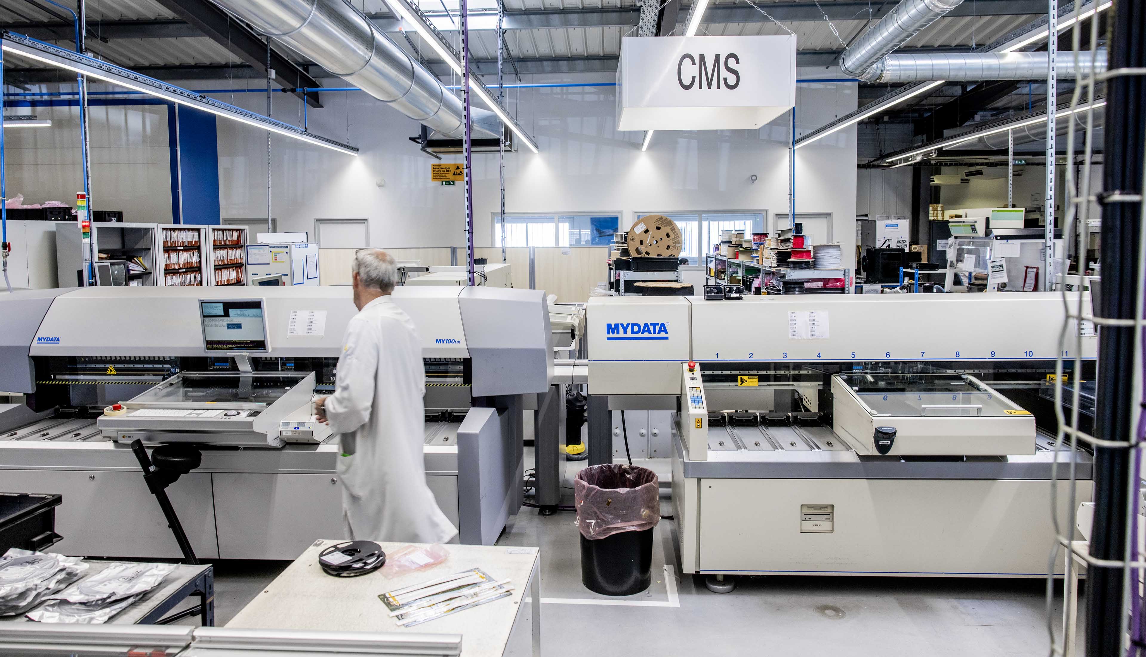 Un homme passe devant des machines dans une usine. 